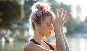 A woman with vibrant pink hair engaged in a yoga pose, embodying tranquility and strength in her practice.