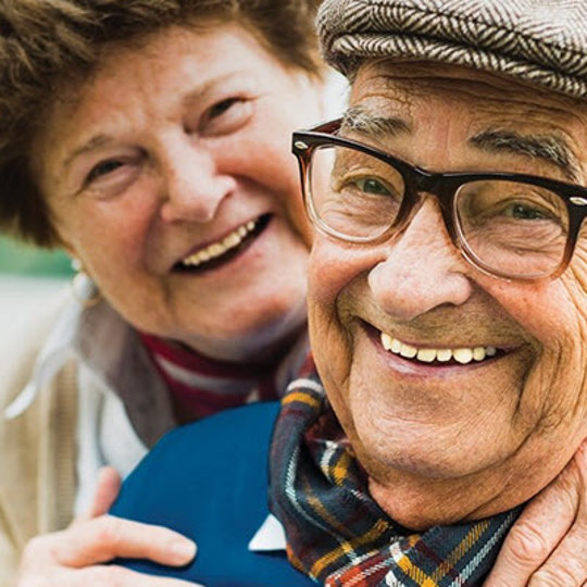 elderly couple embracing and laughing