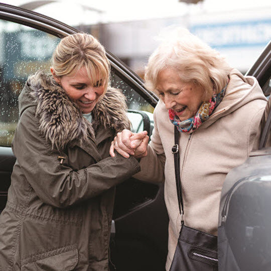 A woman gently holds the hand of another woman, symbolizing support and connection between them.