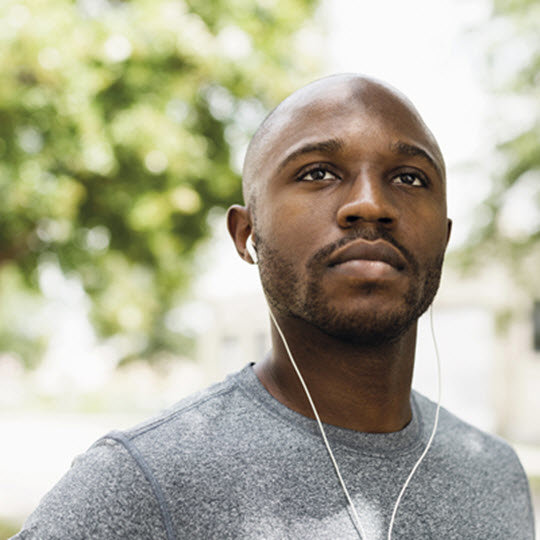 A man with headphones on, immersed in sound, showcasing concentration and enjoyment in his expression.